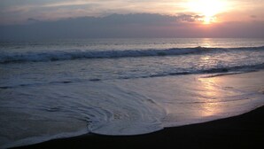 Uma praia com ondas ao pôr do sol.