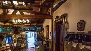 A cozy interior with a wooden ceiling, a stone fireplace, and a dining area with a rug and chairs. - Chez Rumi Butik Otel (Selçuk)