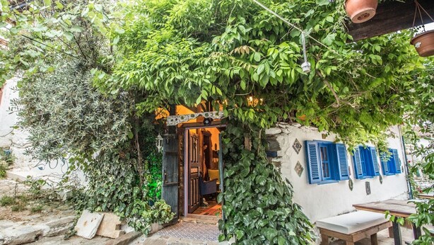 A rustic building with a wooden door and a small porch area. - Chez Rumi Butik Otel (Selçuk)