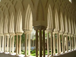 Une série de colonnes hautes et élancées dans une cour.