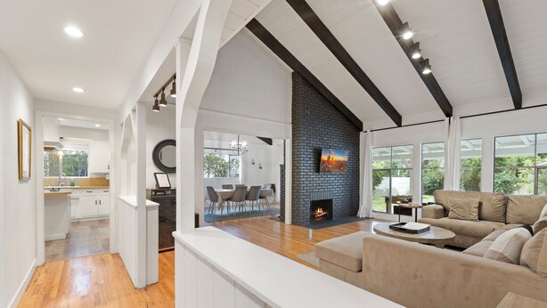 Un salon moderne avec une cheminée, une grande fenêtre et un coin repas.