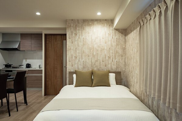 Una habitación de hotel moderna con cama, escritorio y kitchenette.