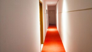 A corridor with a red carpet leading to a door. - Rujia Hotel (Sihanoukville)