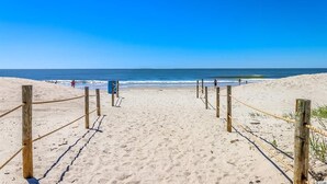 A sandy beach with wooden barriers and a clear blue sky. - Fantastic location!!  Short walk to BEACH, Pools, and WATER PARK!  (Myrtle Beach)