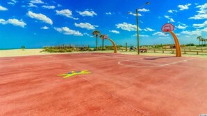 An outdoor basketball court with a red surface, a yellow logo, and a red basketball hoop. - Fantastic location!!  Short walk to BEACH, Pools, and WATER PARK!  (Myrtle Beach)