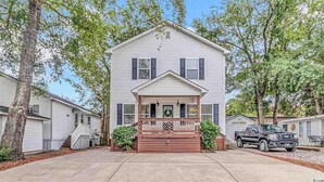 A two-story house with a front porch, a garage, and a driveway. - Fantastic location!!  Short walk to BEACH, Pools, and WATER PARK!  (Myrtle Beach)