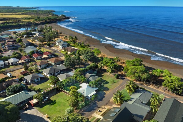 A coastal residential area with houses, a beach, and a clear sky. - Waimea Beach Cottage by Destination Kauai - Charming 2BD, A/C, Walk to Ocean/Pier (Waimea)