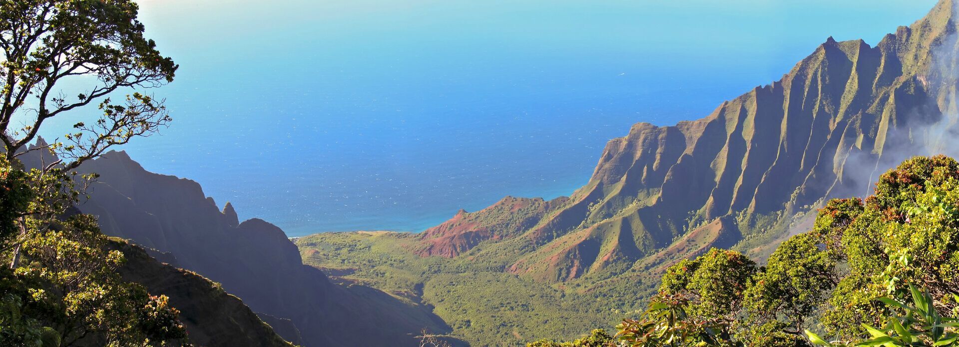 A mountainous landscape with a clear view of the ocean.