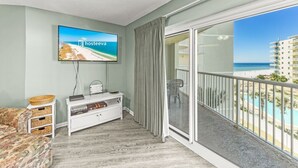 Un balcon avec vue sur la plage et les bâtiments de l’hôtel.