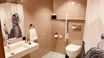 A modern bathroom with a sink, toilet, and shower.