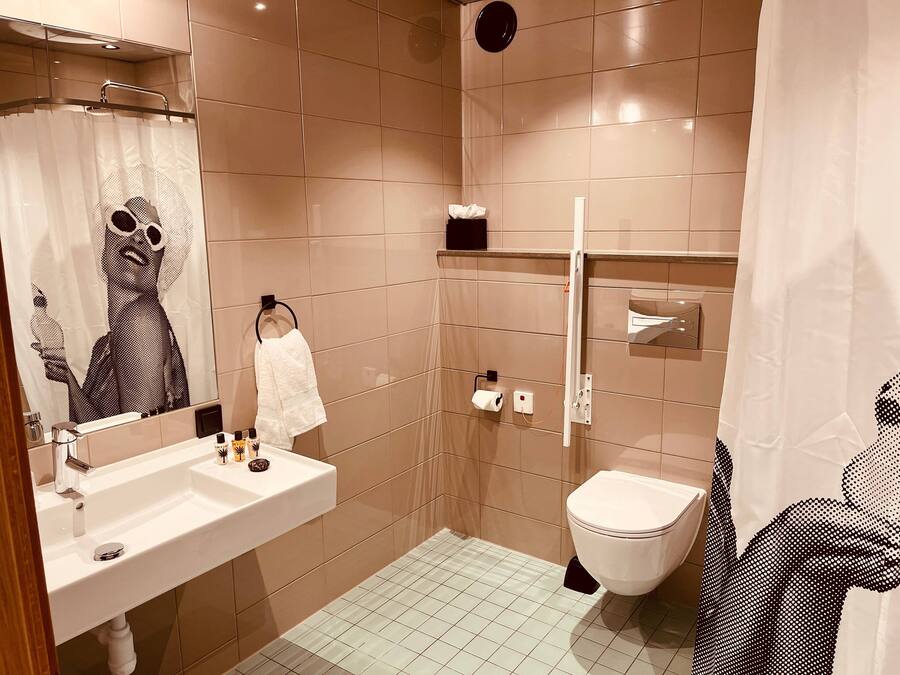 A modern bathroom with a sink, toilet, and shower.