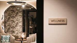 A modern wellness room with a sofa, a small table, and a sign labeled "WELLNESS". - Fritiden Hotell & Kongress (Ystad)