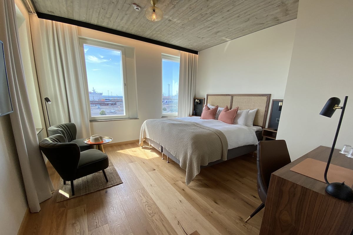 Een moderne hotelkamer met een groot bed, een bureau en uitzicht op de stadszicht.