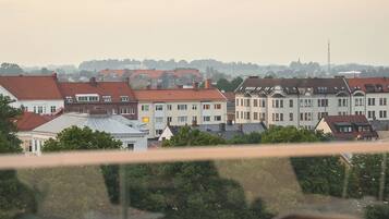 Un comedor con mesa y sillas, con vistas a una hilera de edificios con tejados rojos.