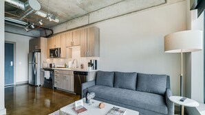 A modern kitchen with wooden cabinets, stainless steel appliances, and a central island. - MINNeSTAY* Sable 607 | North Loop | Target Center (Minneapolis)