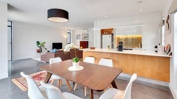 A modern kitchen with a central island, white cabinetry, and a pendant light.