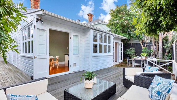 A house with an open garage, a patio with outdoor furniture, and a garden area. - Classic Villa Retreat - Steps To Ponsonby Rd (Auckland Central Suburbs)