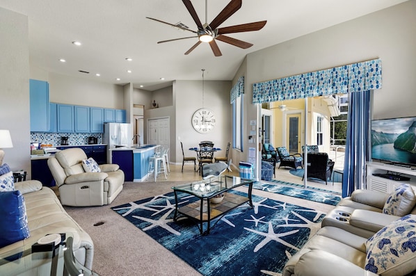 A spacious living area with a kitchen, dining area, and a TV.