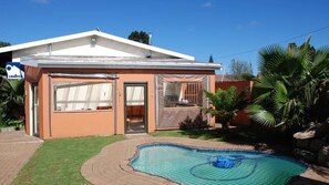 A house with a swimming pool, a covered patio, and a sign for a laundry service. - D & H Guesthouse (Graskop)
