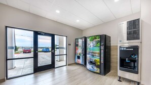 A modern indoor area with a vending machine, an ice dispenser, and a glass door leading outside. - Comfort Inn & Suites Belton Temple South I-35 (Belton)