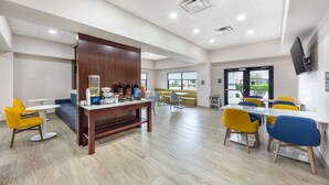 A spacious indoor area with multiple seating arrangements, including tables and chairs, and a central coffee station. - Comfort Inn & Suites Belton Temple South I-35 (Belton)