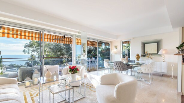 A modern living room with a glass coffee table, white sofas, and a view of the sea through large windows. - Côte d’Azur, Sea View, Tennis, Beach Access (Golfe Juan)