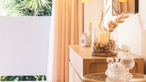 A well-lit room with a wooden vanity, a glass candle holder with dried pampas grass, and a small white figurine on a round table. - Côte d’Azur, Sea View, Tennis, Beach Access (Golfe Juan)