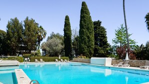 A clear blue pool with lounge chairs and tall trees in the background. - Côte d’Azur, Sea View, Tennis, Beach Access (Golfe Juan)
