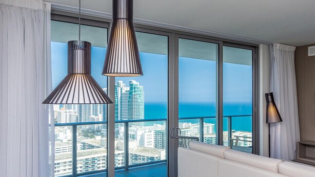 A balcony with a city view, two pendant lights, and a sofa. - Hollywood Beach HHouse Rentals (Hollywood)