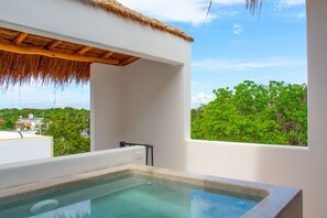 Relax in a serene bathroom with a large bathtub and a view of lush greenery.