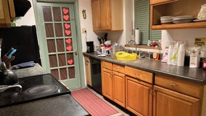 Una cocina con armarios de madera, estufa, fregadero y un tapete rojo a rayas.