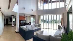 A spacious living area with a high ceiling, a dining area, and a view of the outdoors. - Villa Xona (Castries)