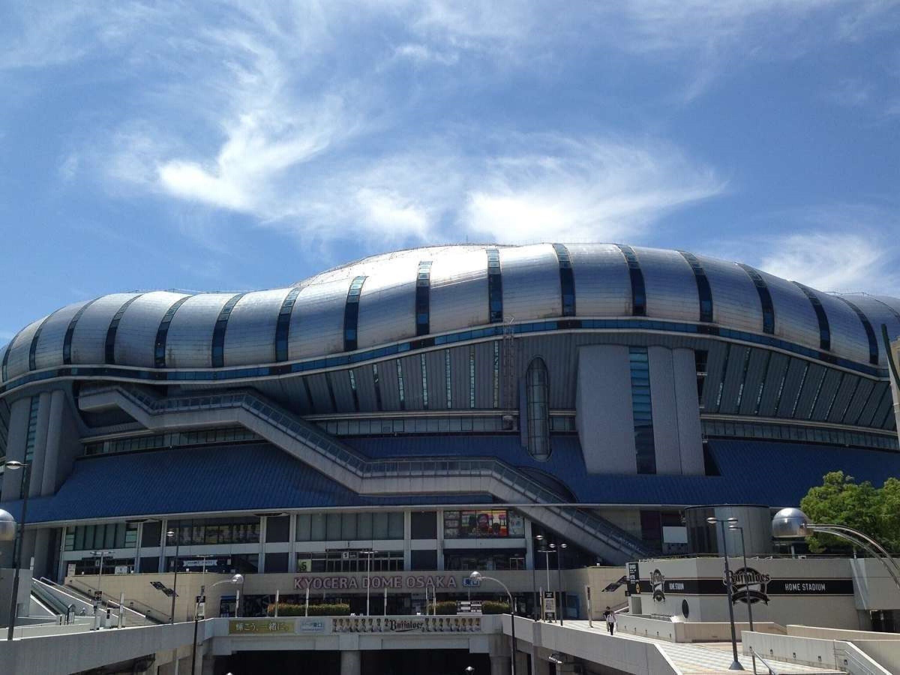 A stadium with a curved roof and multiple levels of seating.