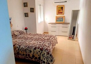 A bedroom with a bed, a dresser, a mirror, and framed pictures on the wall. - Superb Studio in Marrakech hypercentre 4581 (Marrakech)
