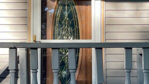 Een huis met een houten deur en een glazen raam met decoratieve details.