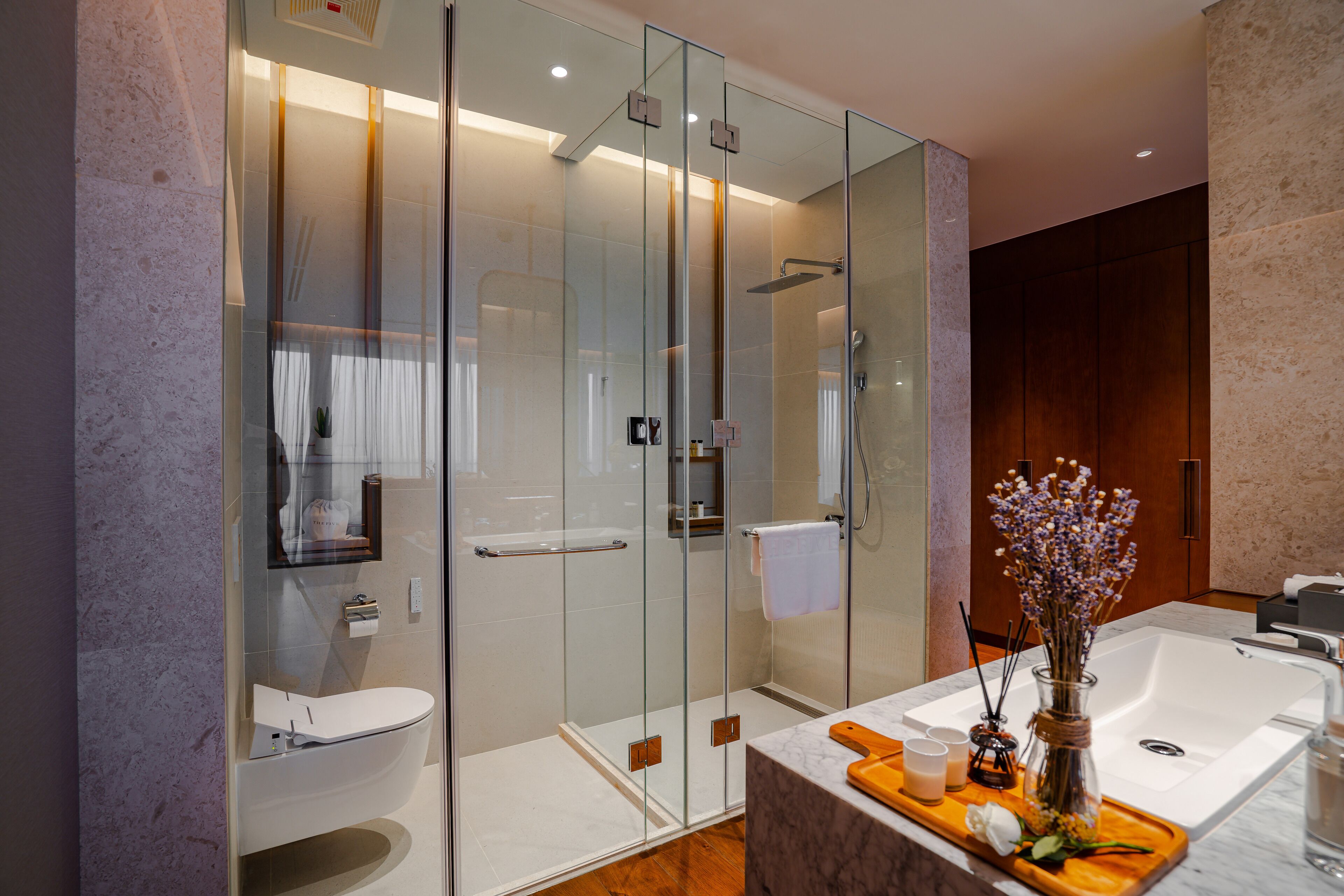 A modern bathroom with a glass-enclosed shower, a white sink, and a large bathtub.