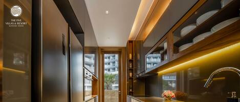 A modern kitchen with a central island, built-in appliances, and a view to the outside.