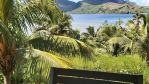 A bench overlooking a tropical landscape with a view of a lake and mountains. - Ocean view garden homestay (Wayasewa)