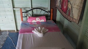 A bed with a metal frame, a white mattress, and a pink polka-dotted pillow. - Ocean view garden homestay (Wayasewa)