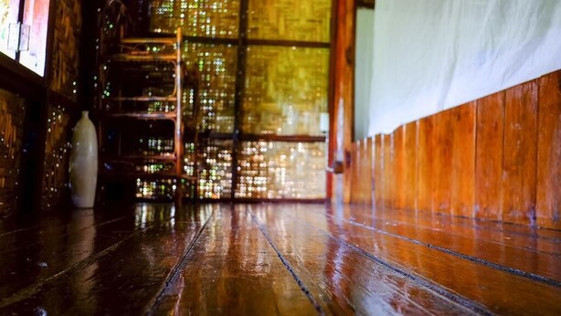 Suelo de madera con una puerta de cristal que da a una habitación con vistas.