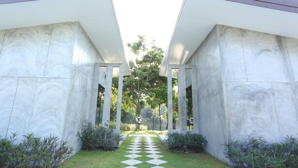 A modern building with a checkered pathway leading to a glass door entrance.