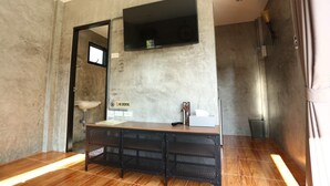 A modern bathroom with a wooden vanity, a large mirror, a sink, and a shower area.