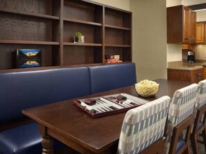 A dining area with a wooden table, blue cushioned bench, and patterned chairs. - Streamside at Vail Birch (Vail)