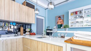 Eine moderne Küche mit Holzschränken, einer weißen Arbeitsplatte und einer blauen Wand.