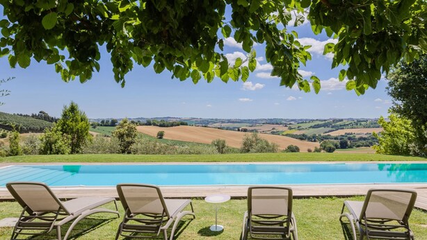 A poolside area with lounge chairs and a view of rolling hills. - Modern villa with heated pool and Jacuzzi, near Ripe, just 20 minutes from the beach of Senigallia (Trecastelli)