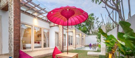 A patio area with a pool, outdoor seating, and a pergola.