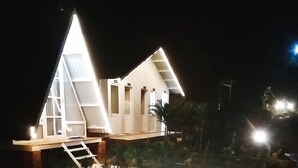 Un bâtiment doté d’un toit triangulaire, d’un escalier apparent et d’un petit espace porche.