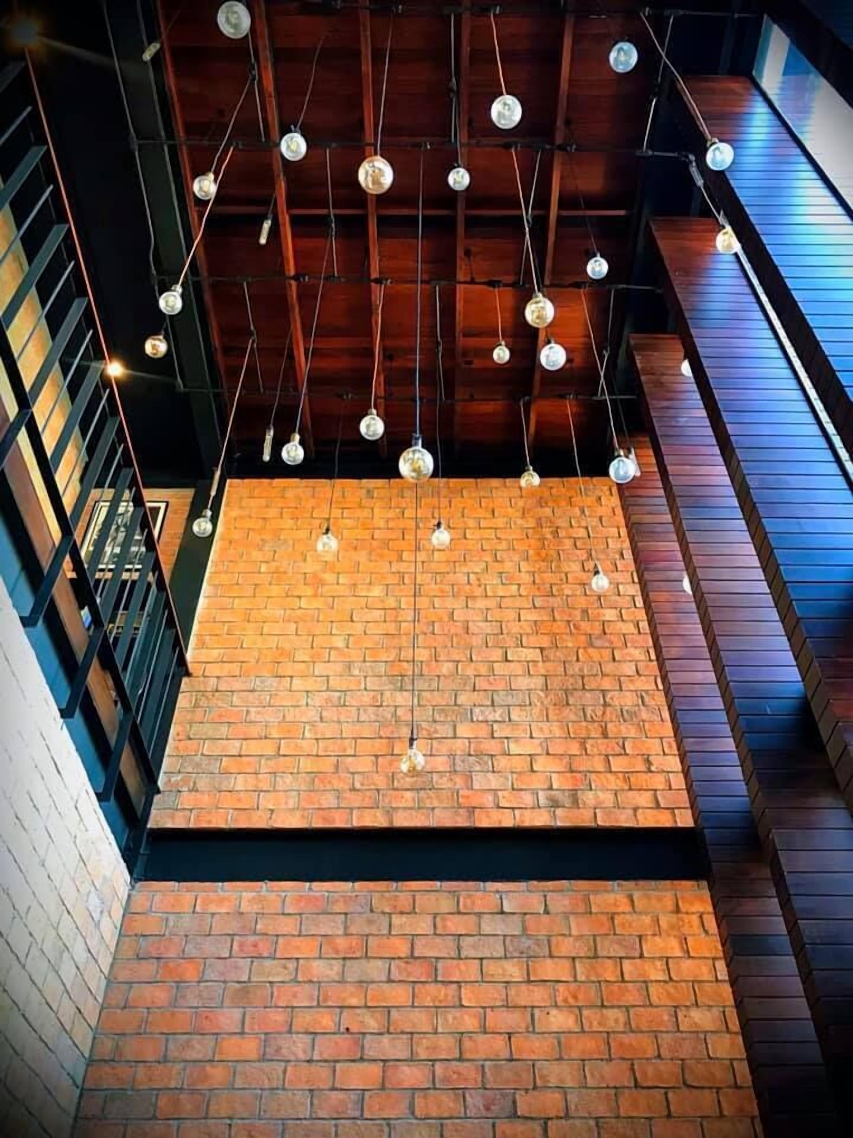 A multi-level interior with exposed brick walls and wooden beams.