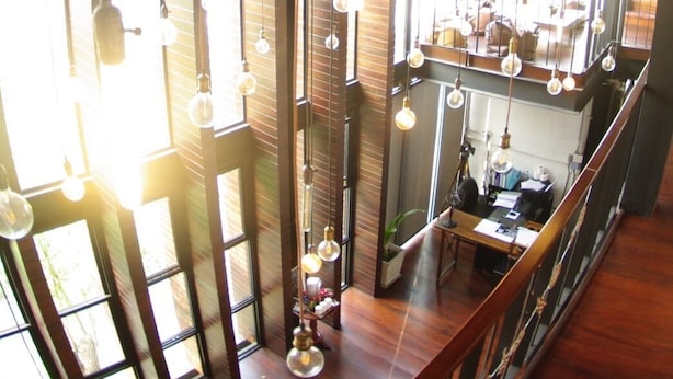 A spacious interior with high ceilings, large windows, and hanging light fixtures. - The LOCAL Ari - Hostel (Bangkok)