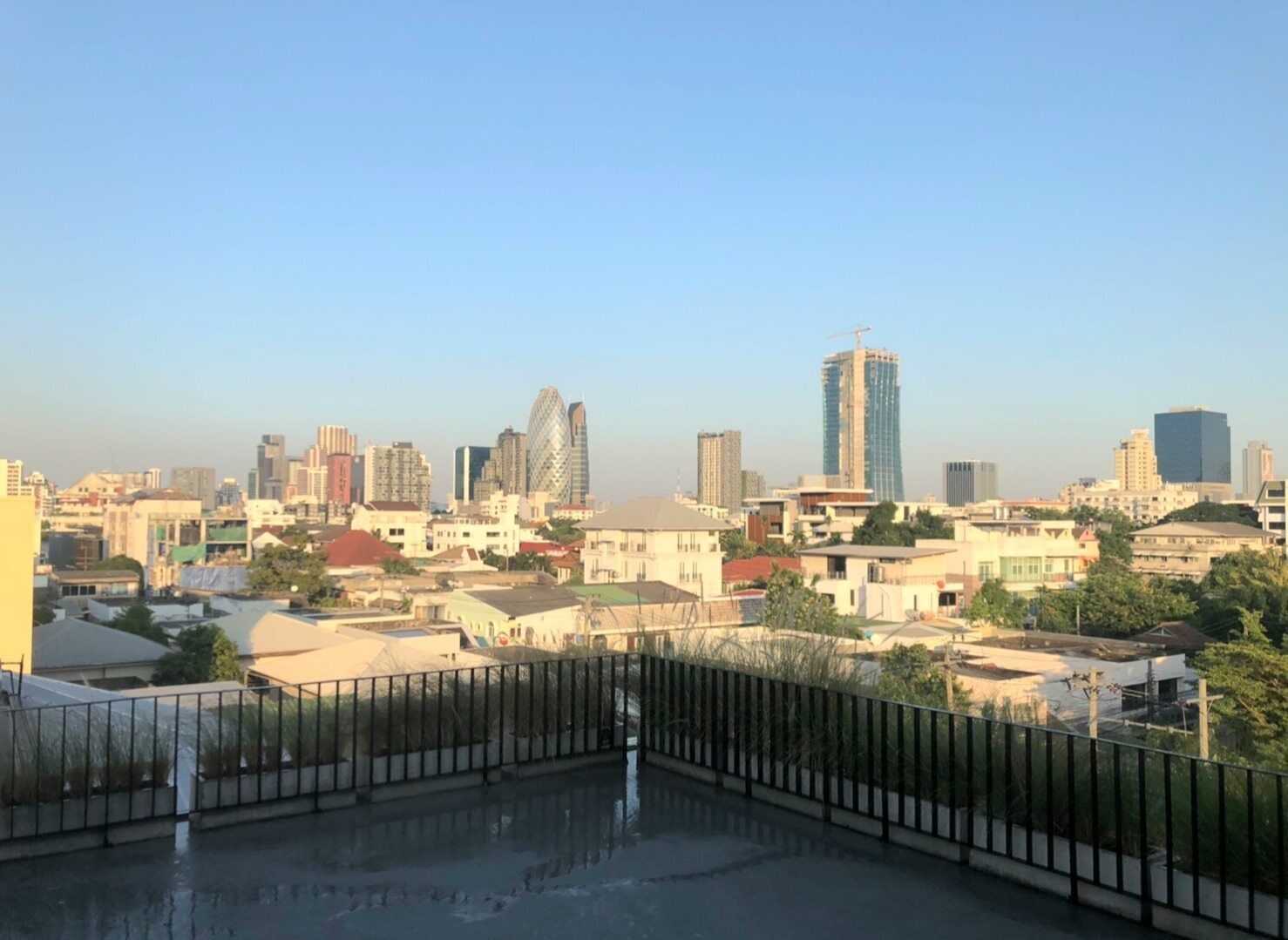 A cityscape with various buildings, including a prominent skyscraper under construction.